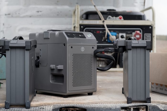 TERNOPIL REGION, UKRAINE - May 06, 2023 - the process of charging with a charging station of two agrodrone sprayer DJI AGRAS T30 batteries from a generator in the field
